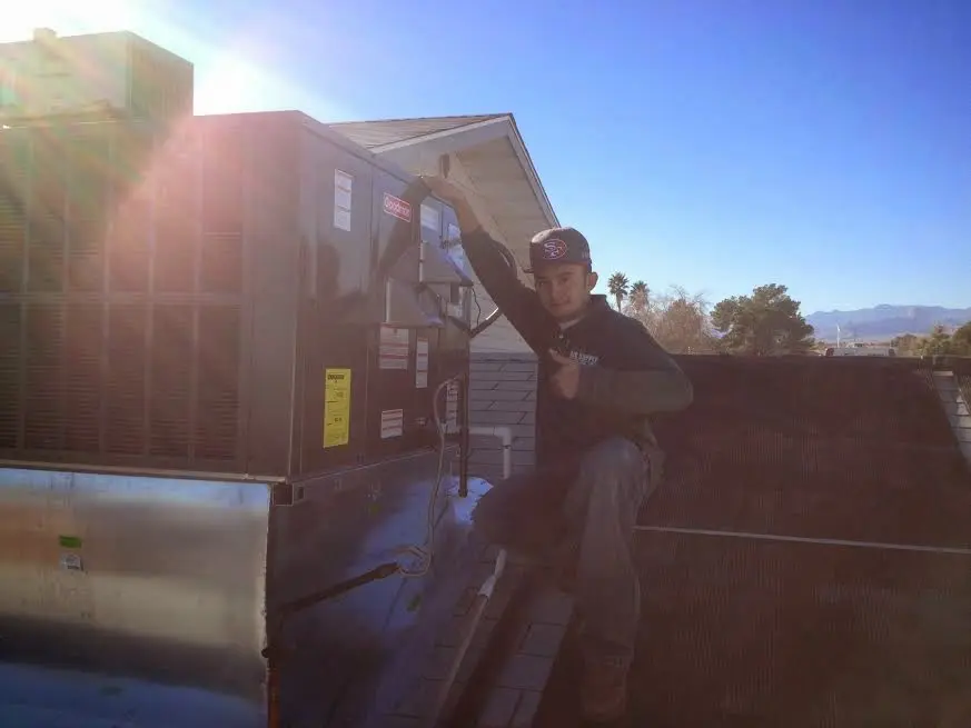 HVAC technician performing AC Tune-Up on a rooftop unit in Kinston